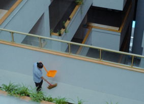 A man with a broom is sweeping the street
